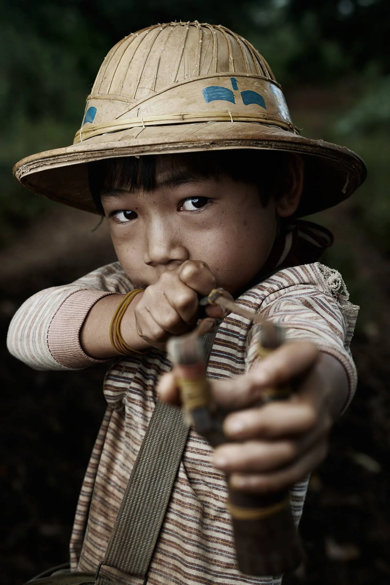 This 8 years old burmese guy is a "bird hunter". I had the opportunity to met him in my last trip to Burma in a remote region of the country. My guide was the translator. The guy explained us that he spend his life hunting birds in the morning to have something to eat every day. His parents consider a waste of time to send him to the school because he will not need that knowledge in his country in the future. - Victor Gonzalo