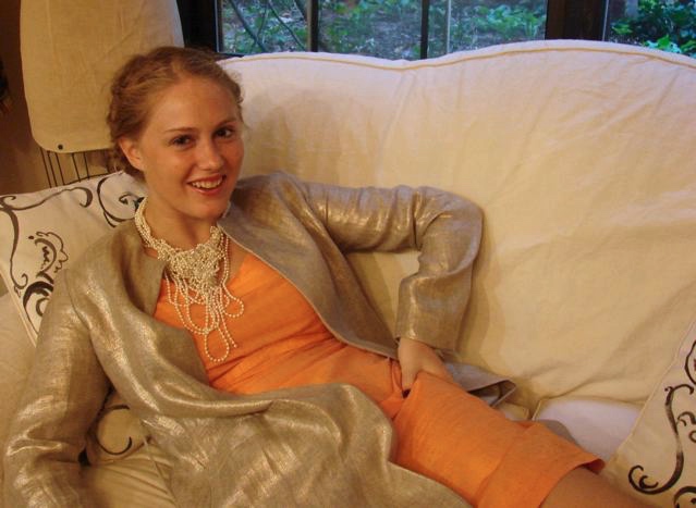 El is wearing a silk shantung fitted dress with 3/4 sleeves and a metallic finish linen coat and, of course, pearls!
