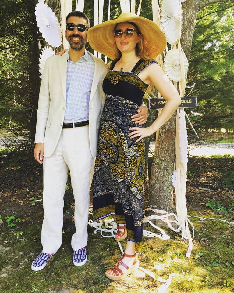 Bethany is wearing a Wax-print ankle-length dress to a summer wedding in the Hamptons - looking fabulous with her dapper husband. . .accessorized with wide-brimmed straw hat and summer sandals.