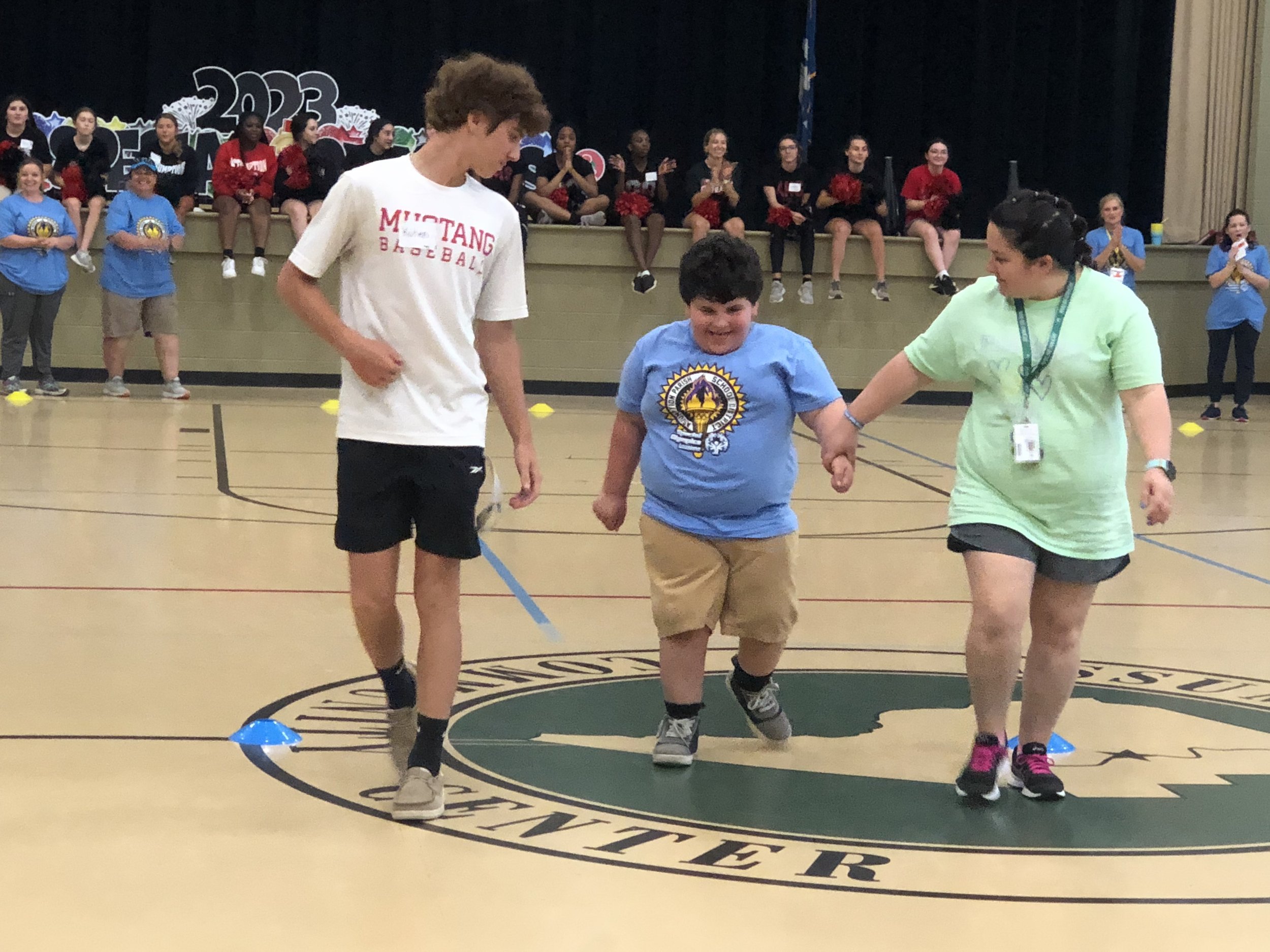  Assumption Parish Public Schools’ Special Olympic Athlete Jaxon Blanchard, center, is assisted by Assumption High School senior Kohen Cavalier, left, and teacher Crystal Aucoin, right, during his race competition. 