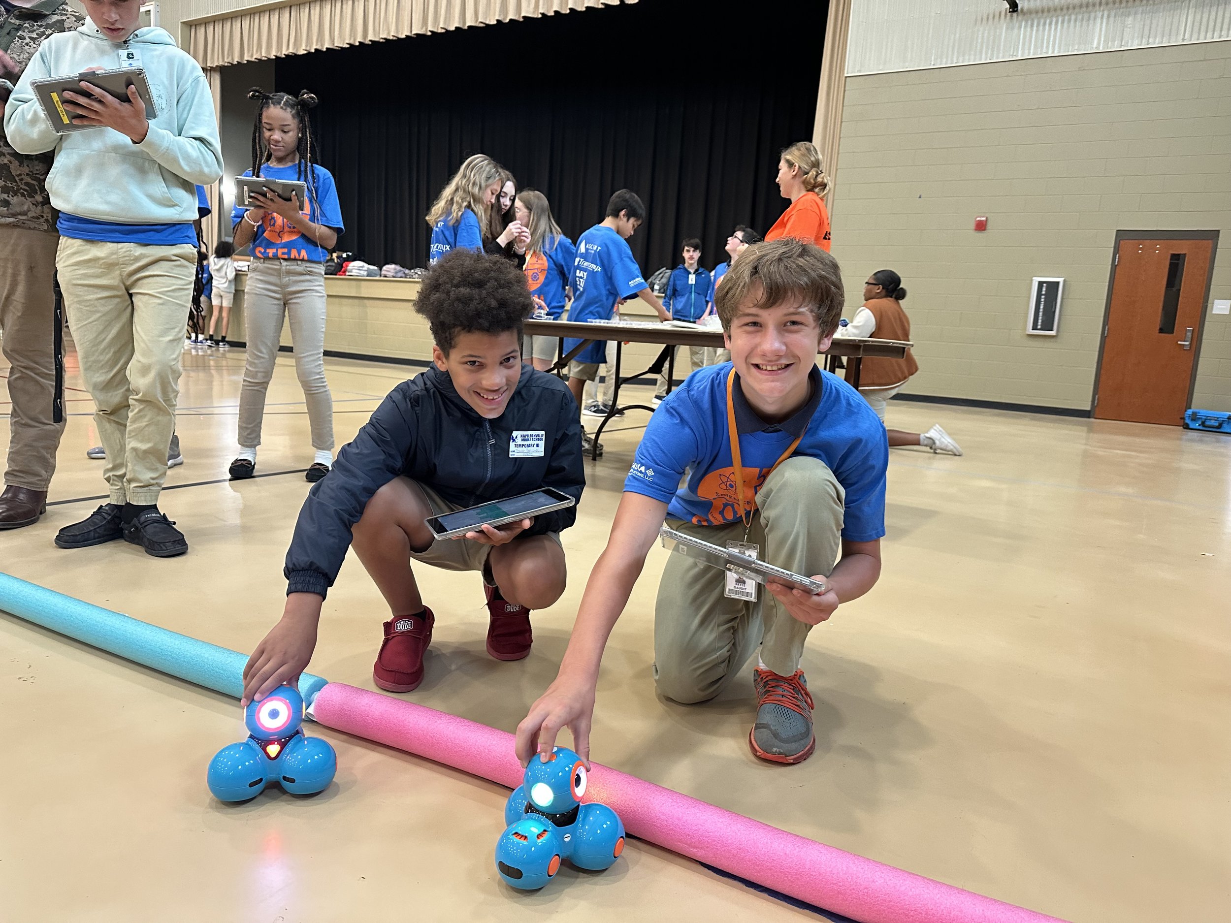  Napoleonville Middle School students Isaiah Chalubiec, left, and Bryce Gaudet, right, remotely operate small robots by programming commands on their iPads during the Assumption Parish STEM Challenge Day. 