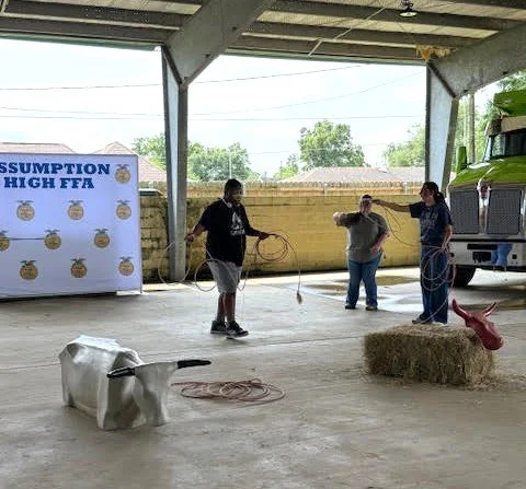  FFA Volunteers Maycee Pleasant and Rubie Parkinson show Special Rodeo participants how to throw a lasso. 