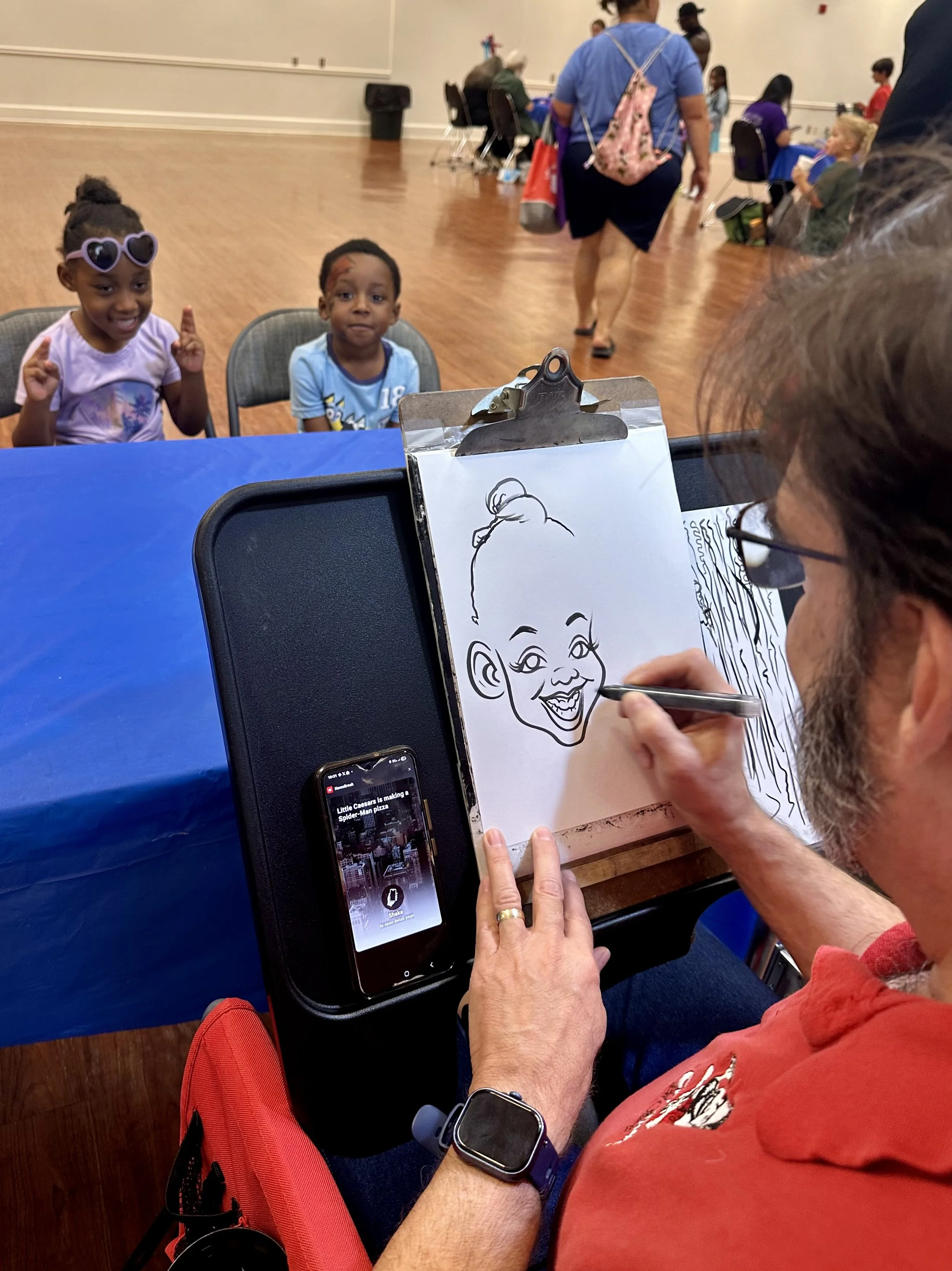  Five-year-old Isabell Harris poses for her caricature sketch as her four-year-old brother Byson Harris awaits his turn. The caricatures were provided by artist Steve Shamburger during Assumption Parish School’s Early Childhood Day. 
