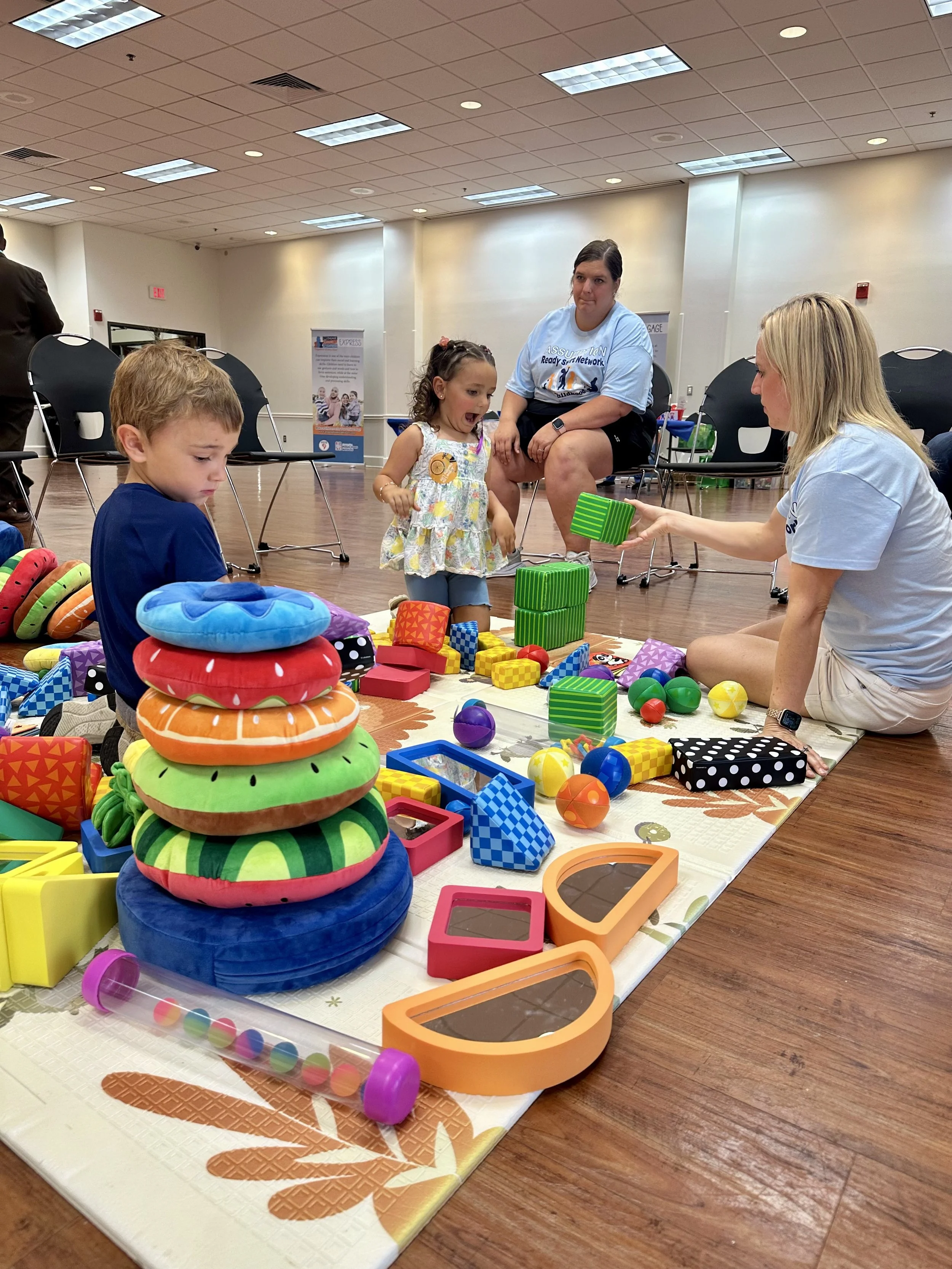  Zane Bailey and Delilah Marcel enjoying playing wit the colorful blocks and cushions available to them at the Assumption Parish Schools’ Early Childhood Day. Head Start Paraprofessional Rayne Talbot and Pre-K teacher Aimee Landry help the children s