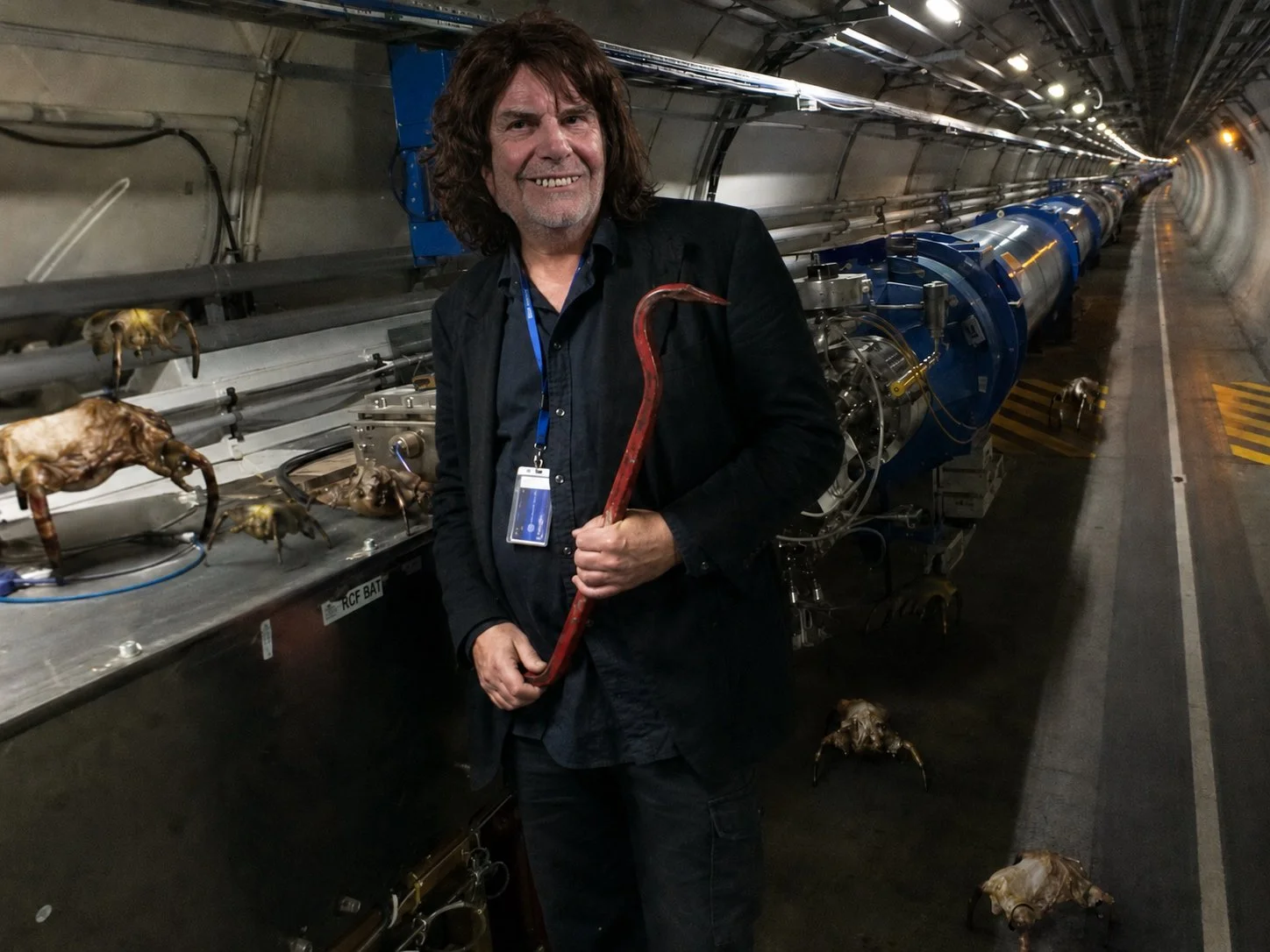 AI-generierte Fotomontage zeigt "Dr. Tobi Erdmann" im LHC am Cern mit einer Brechstange gegen Monster aus Half-Life kämpfen. Satirisches Meme aus Das Letzte Wiki.