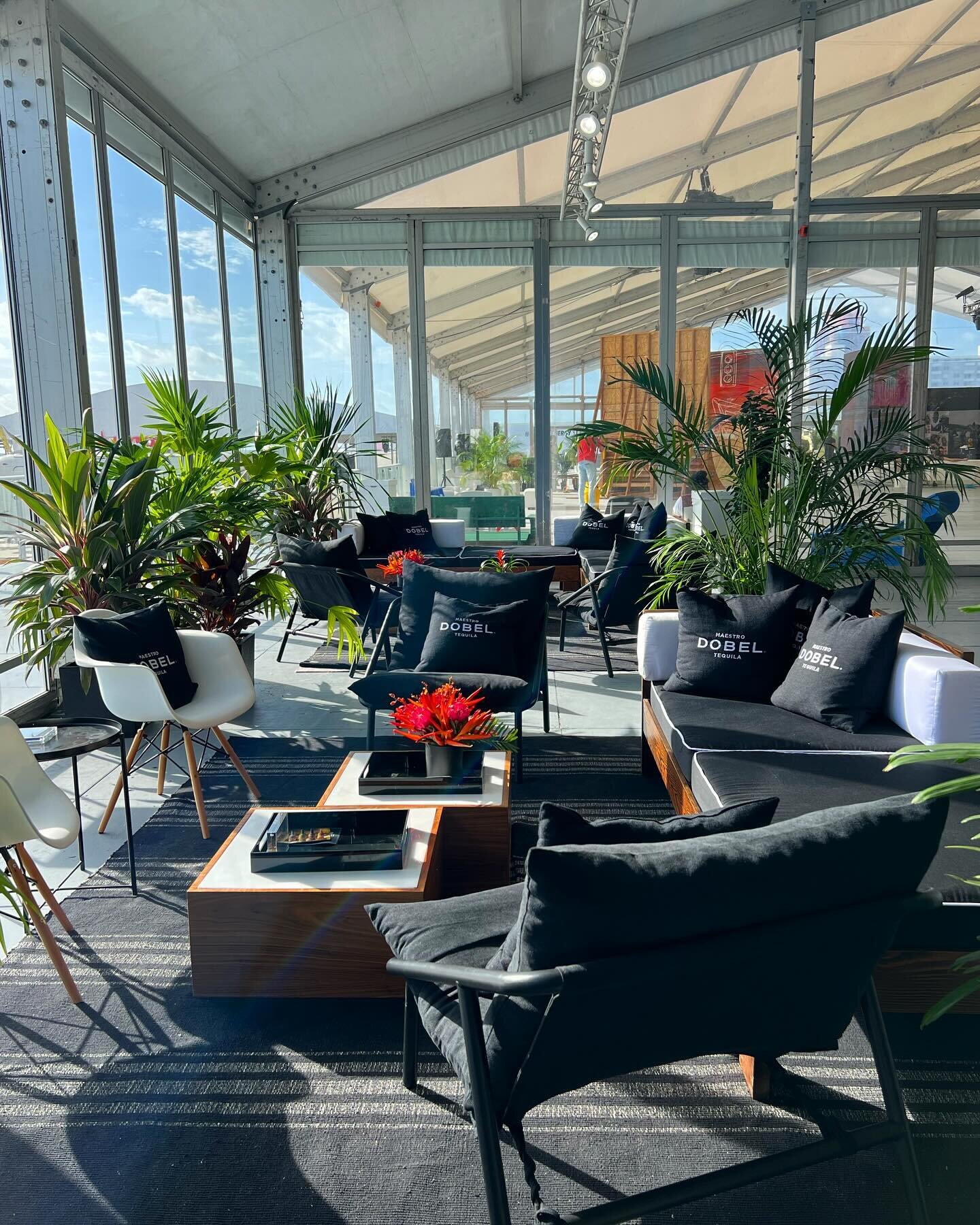 Black tones and greens plants look so beautiful together at the Dobel Lounge at @scopeartshow designed by @max.ries 

Furniture: Lounge Chair with Black cushions, Walnut Tables, Black Accent Chairs, Eames Replica Chairs 
.
.
.
#eventfurniture #eventr