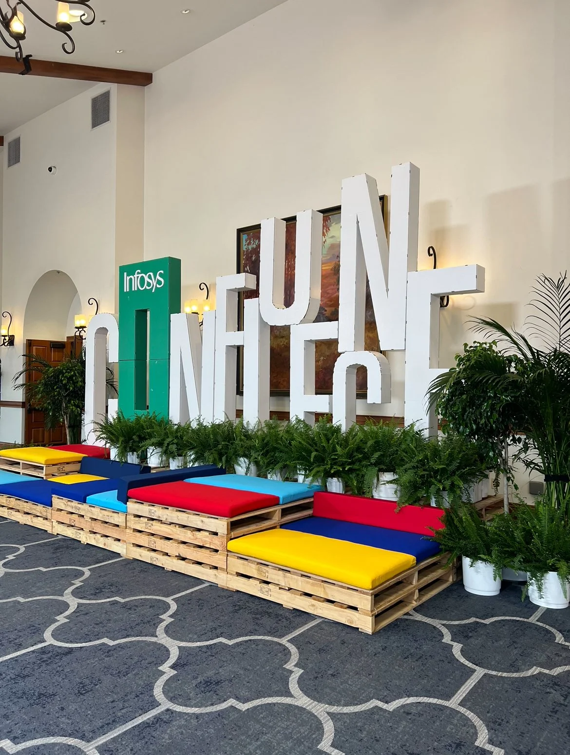 A Multi Level pallet lounge with colorful cushions and large lettering in the back