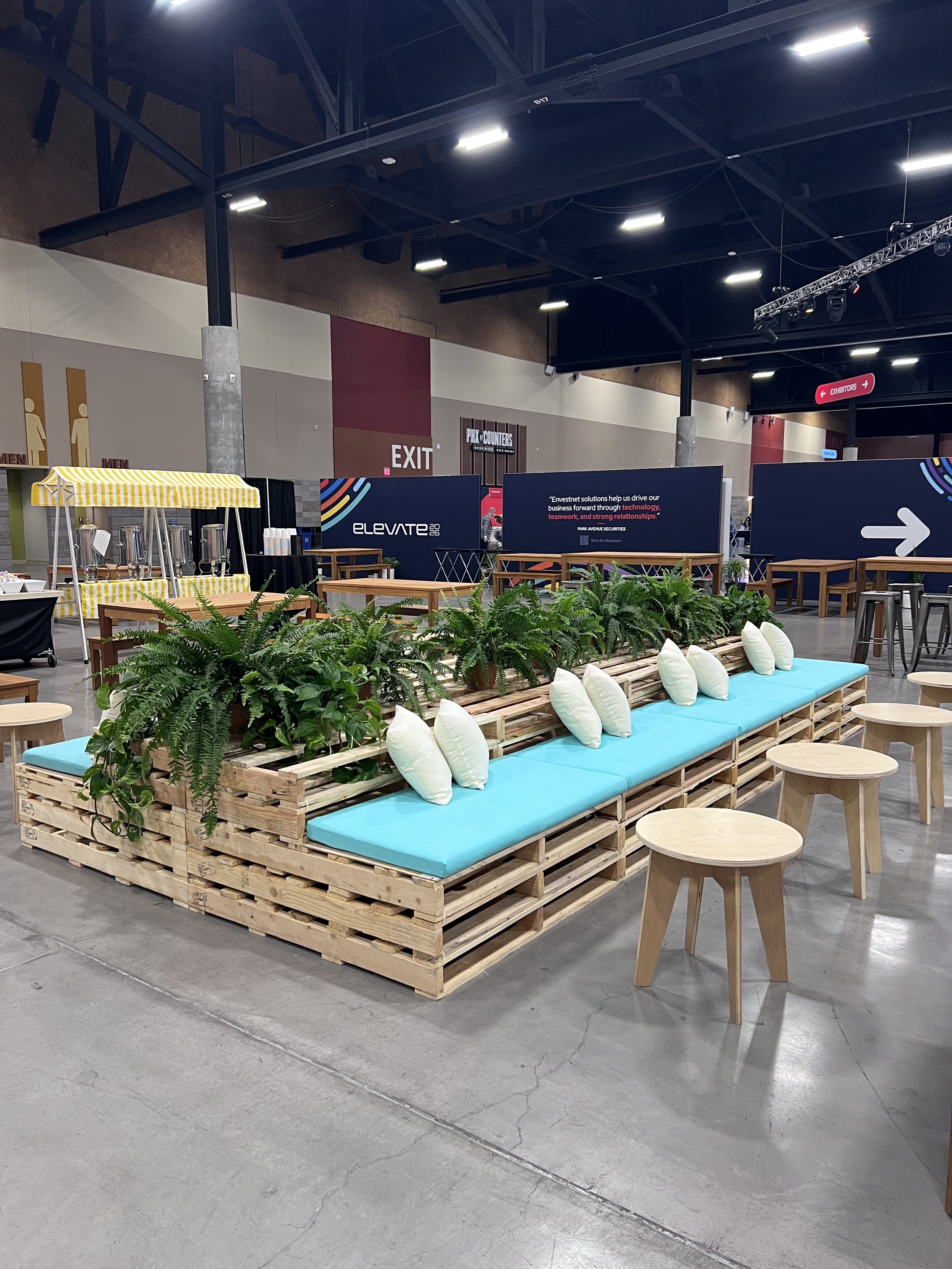 16' Back to Back pallet furniture lounge with plants and Aqua cushions at a conference in Phoenix, Arizona