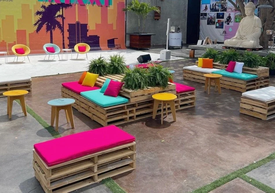 Pallet furniture with colorful cushions and side tables for an event at Maps Backlot in Miami
