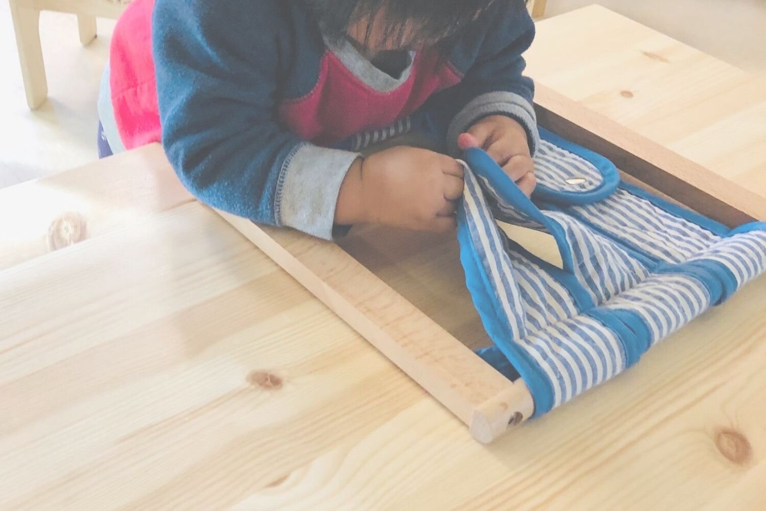 Child Working With Dressing Frame