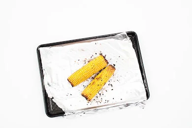 Preheat the oven to 200C, place the corn on a roasting tin with olive oil, salt, pepper and chilli flakes . Cook in the oven for 35 minutes turning every 10 minutes.