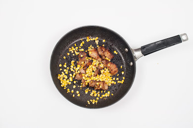 Add the corn to the pan and mix with the pork.