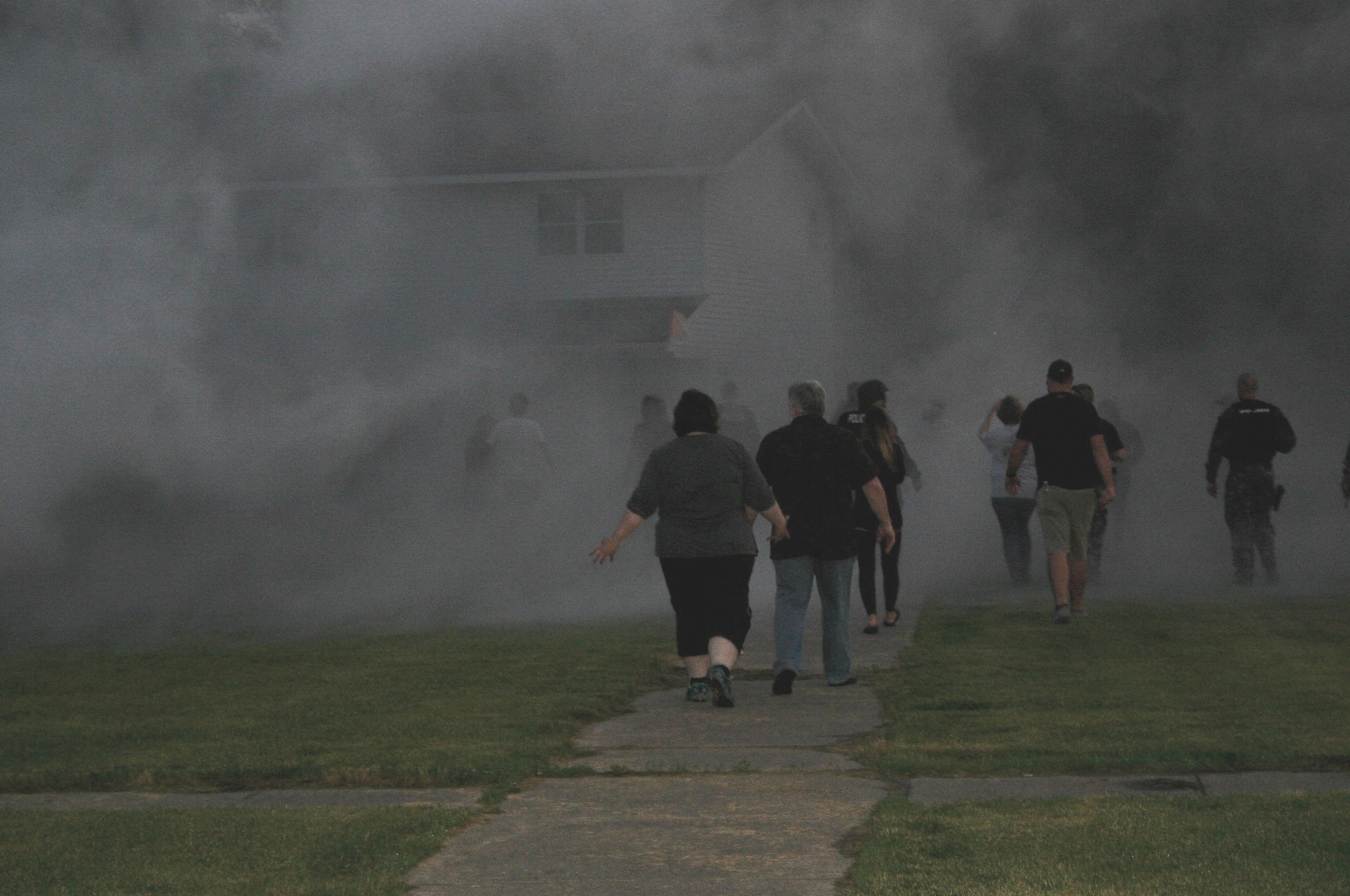 Participants walk into a cloud of smoke from one of SWAT's smoke canisters.  