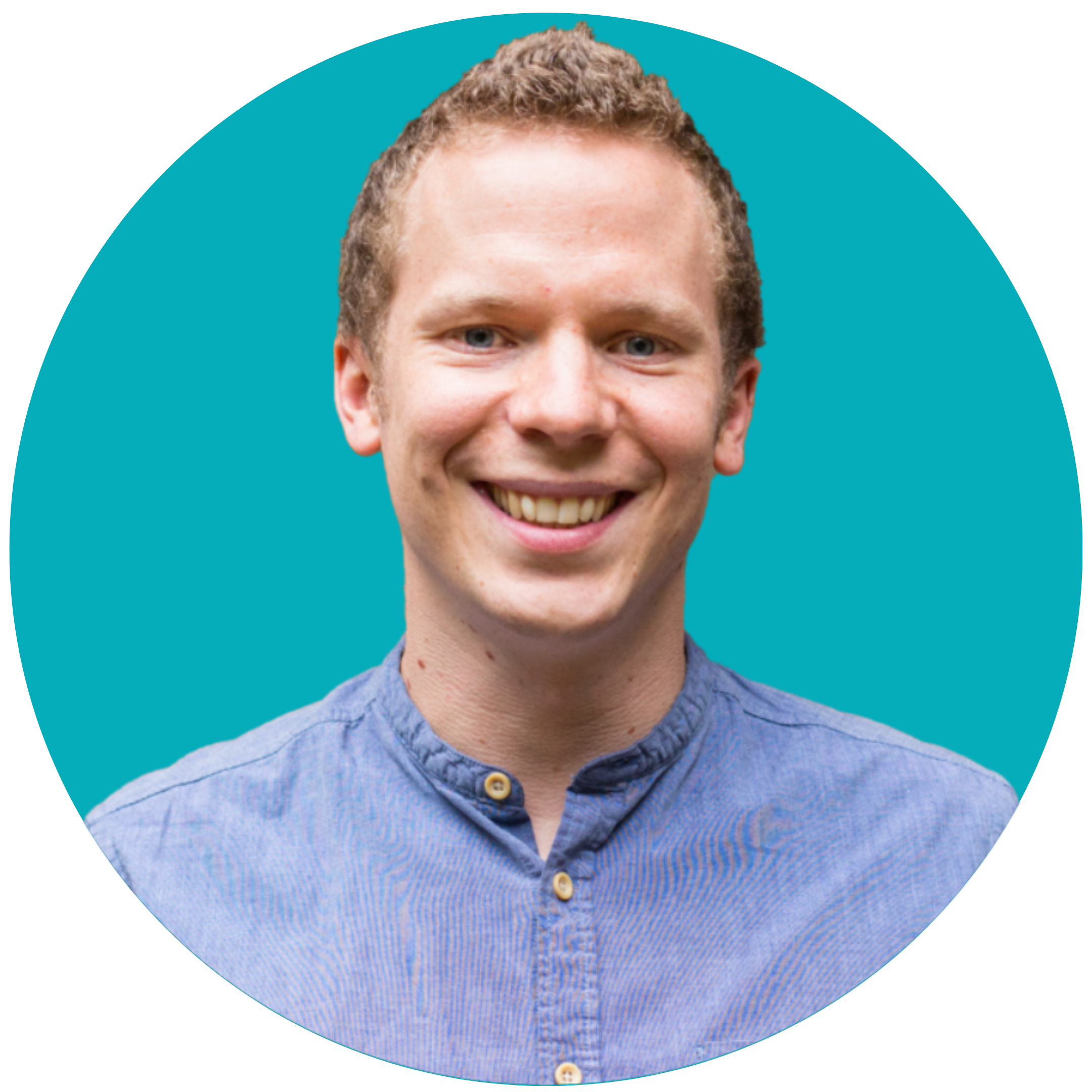 A man with curly blonde hair smiles at the camera. He is wearing a blue shirt and is set against a teal background.