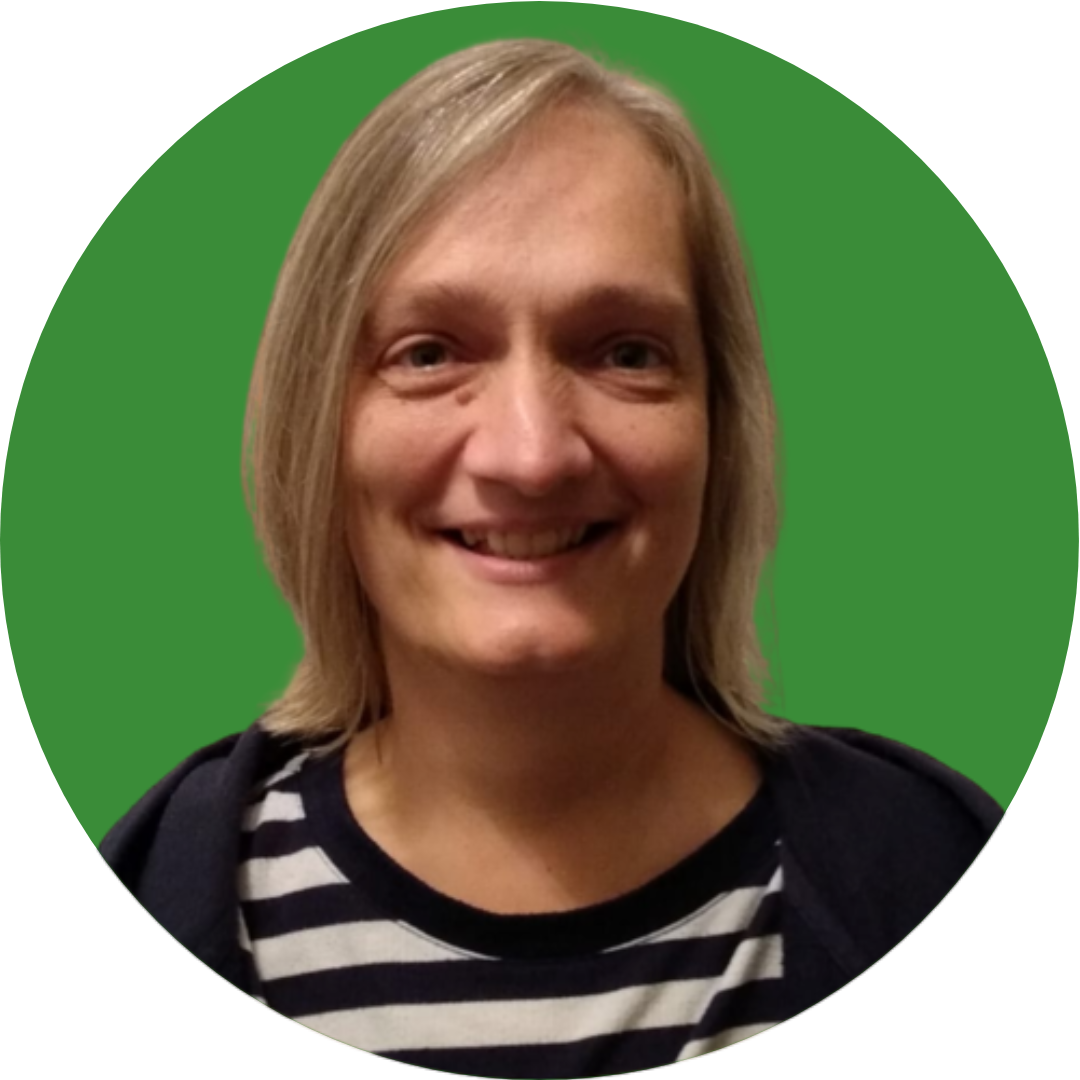A woman with short grey hair smiles at the camera. She is wearing a striped top and is set against a dark green background.