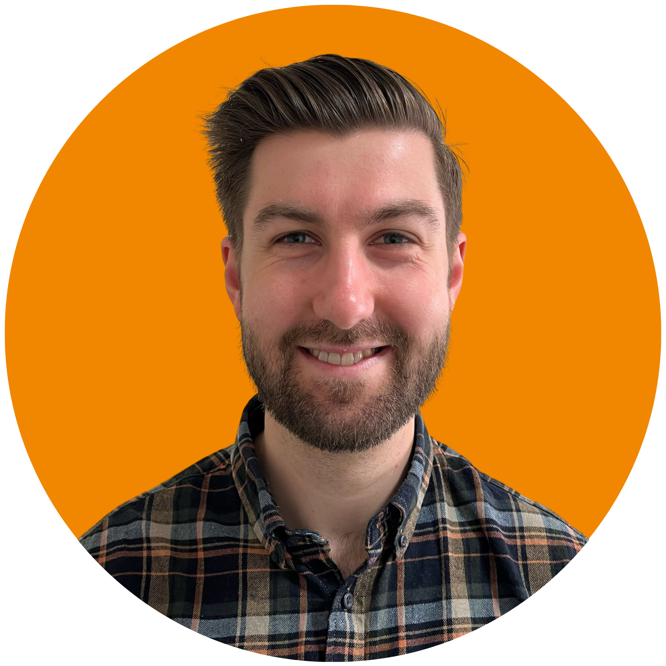 A man with brown hair and a beard smiles at the camera. He is wearing a checked shirt and is set against an orange background.