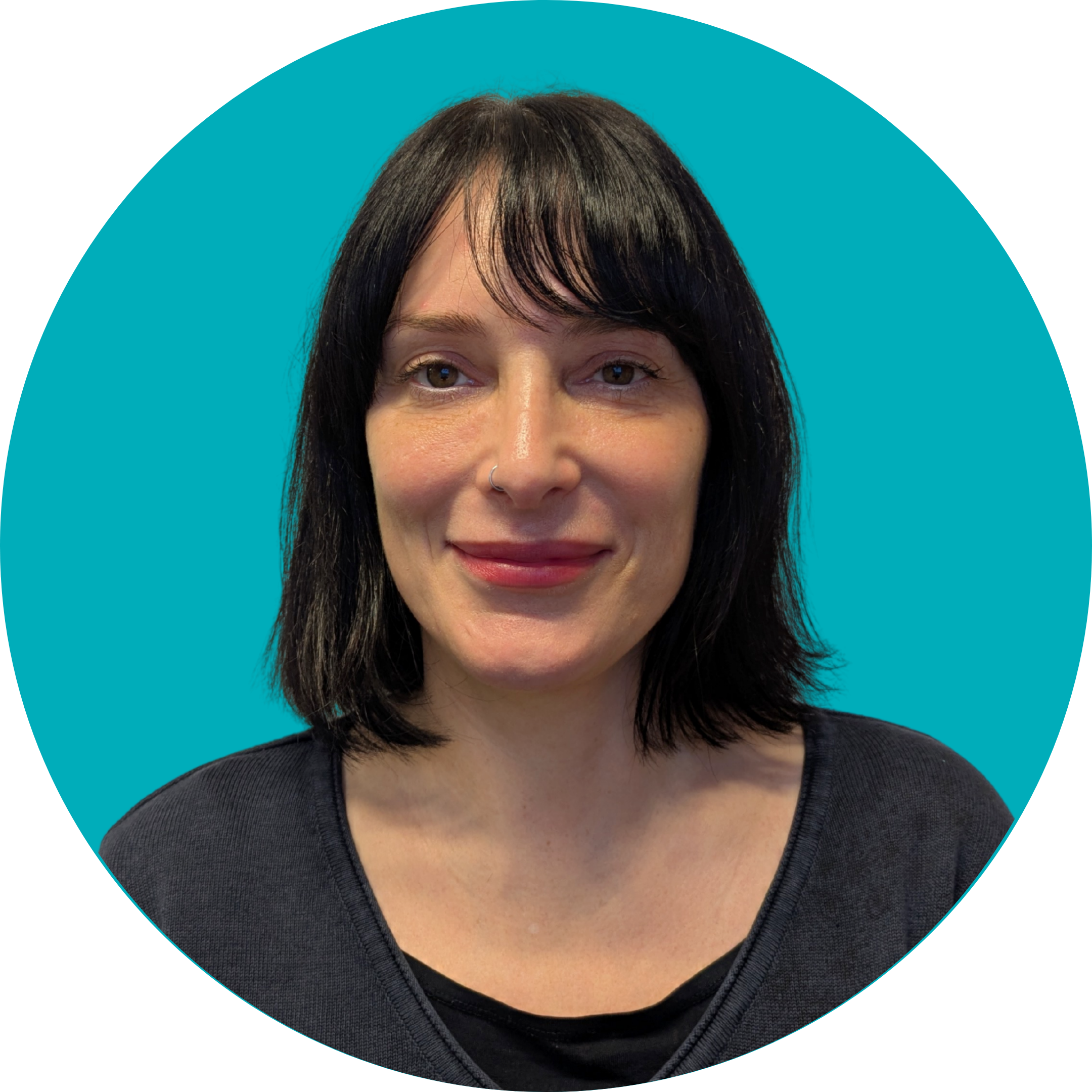A woman with a dark brown bob and a fringe smiles at the camera. She is wearing a dark top and is set against a teal background.