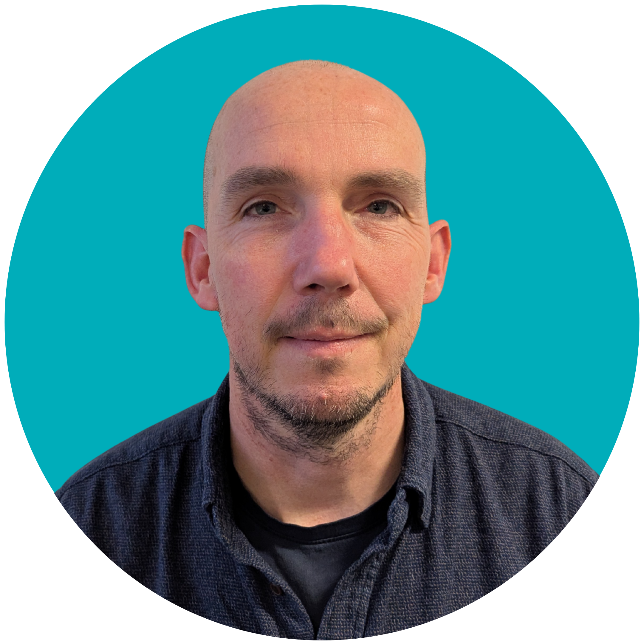 A bald man with stubble, wearing a dark shirt, set against a teal background.