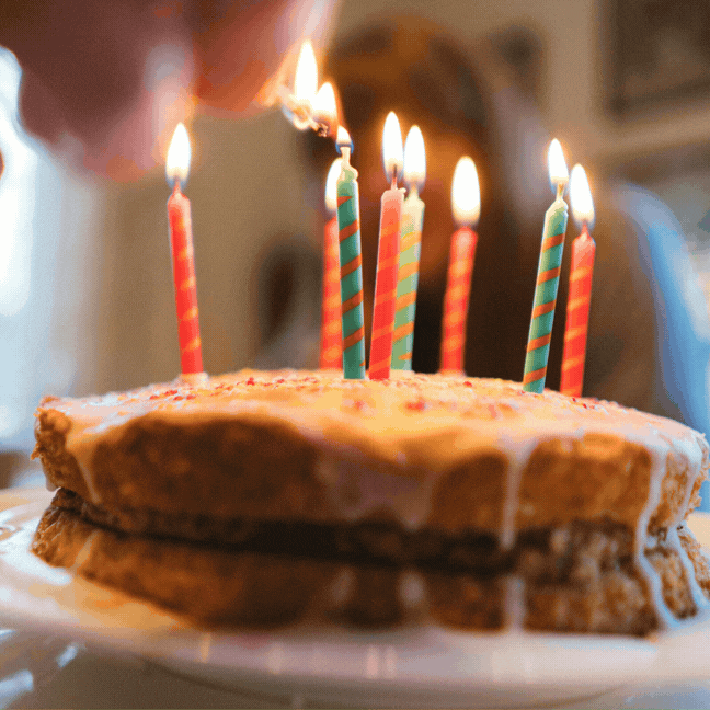 Image of a birthday cake with candles lit. The text overlaid says 'donate your birthday'.