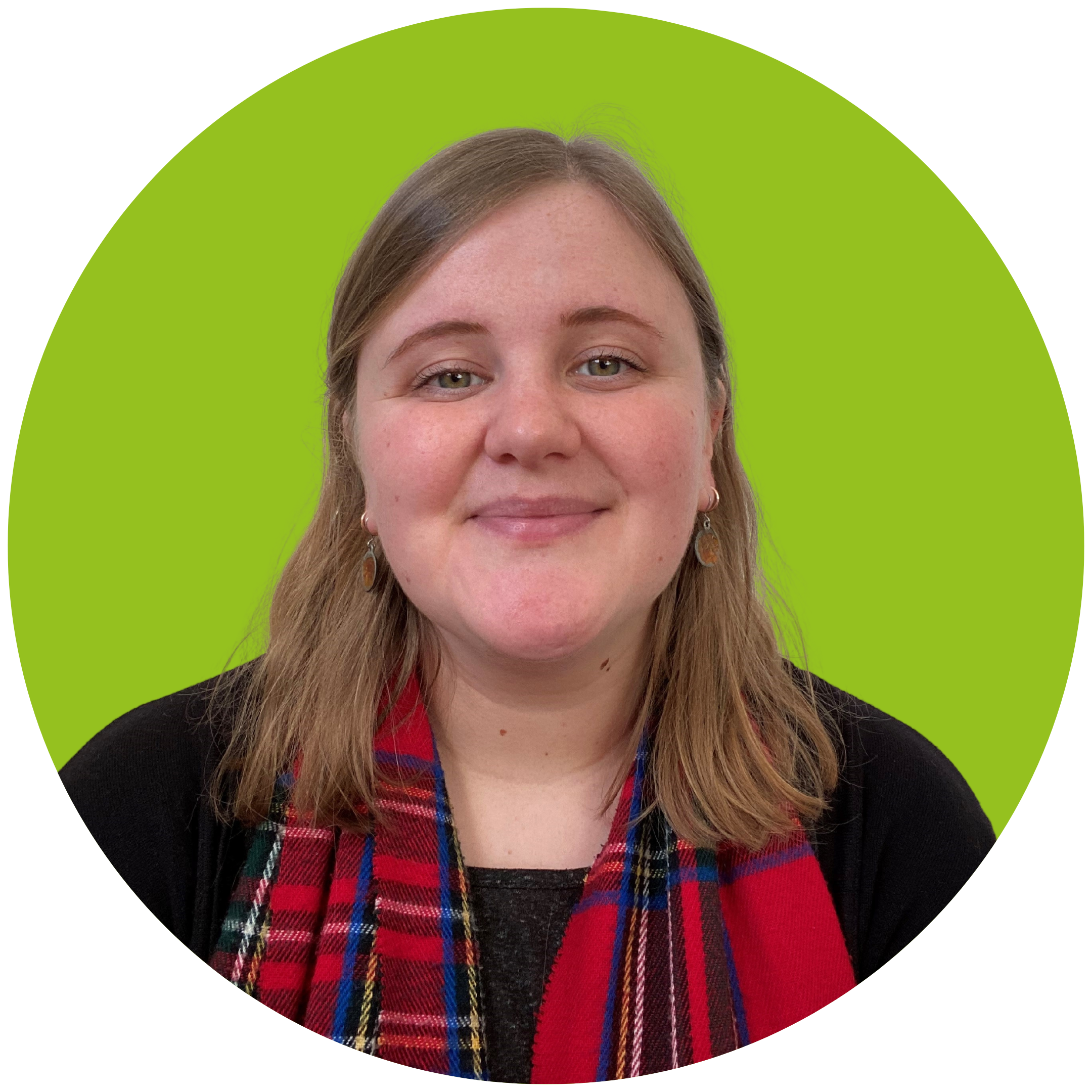 A blonde woman smiles at the camera. She is wearing a black top with a red tartan scarf, and is set against a light green background.