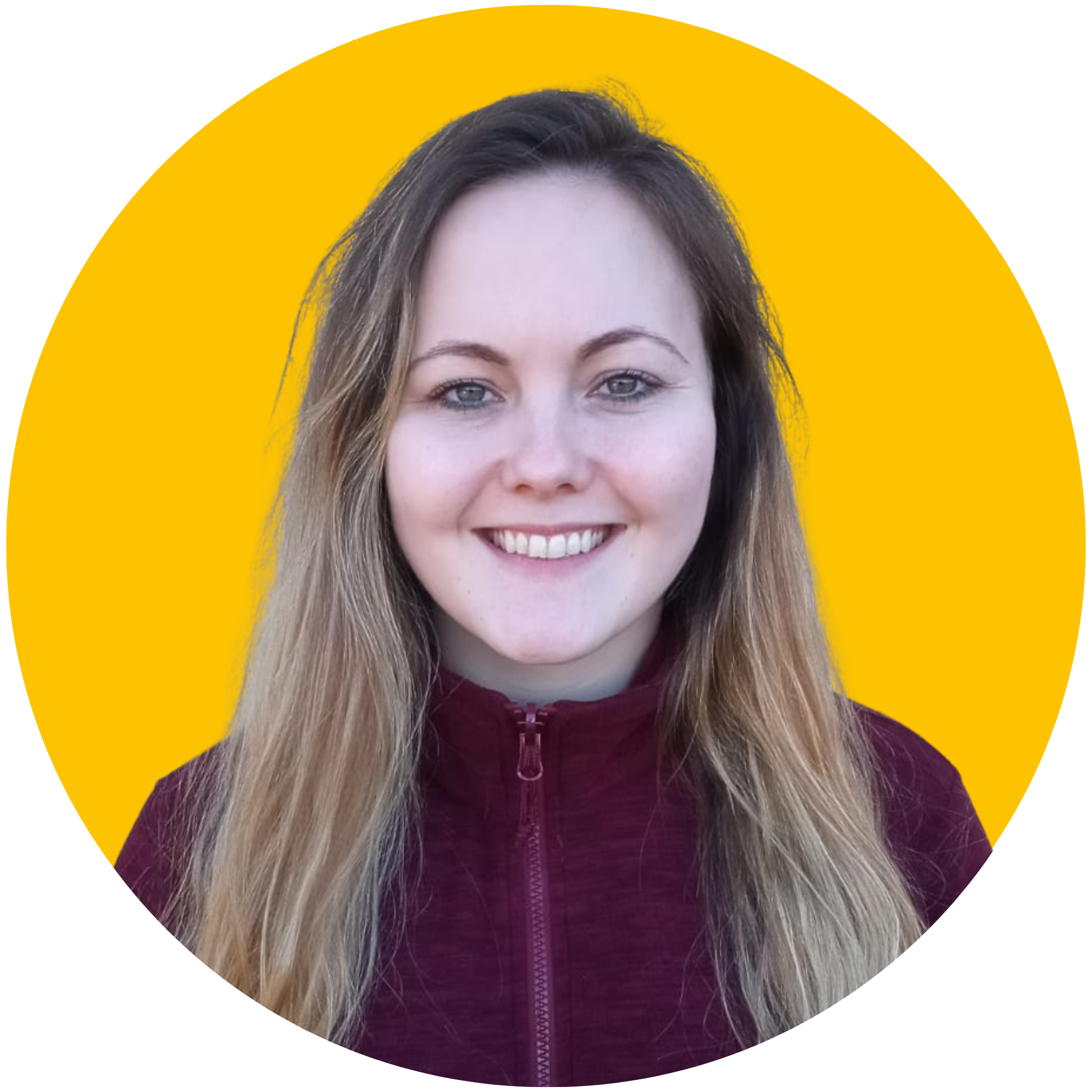 A woman with long blonde hair smiles at the camera. She is wearing a red fleece and is set against a yellow background.