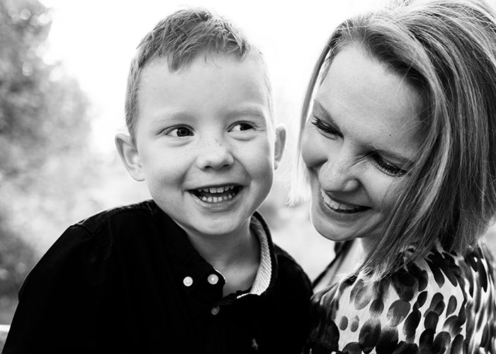 Black and white portrait of mother and son sharing a moment giggling.jpg