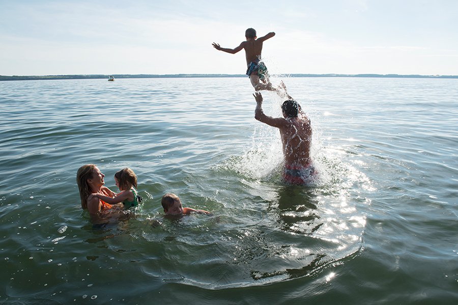 Family of five playing in water - dad launching one child into the water.jpg