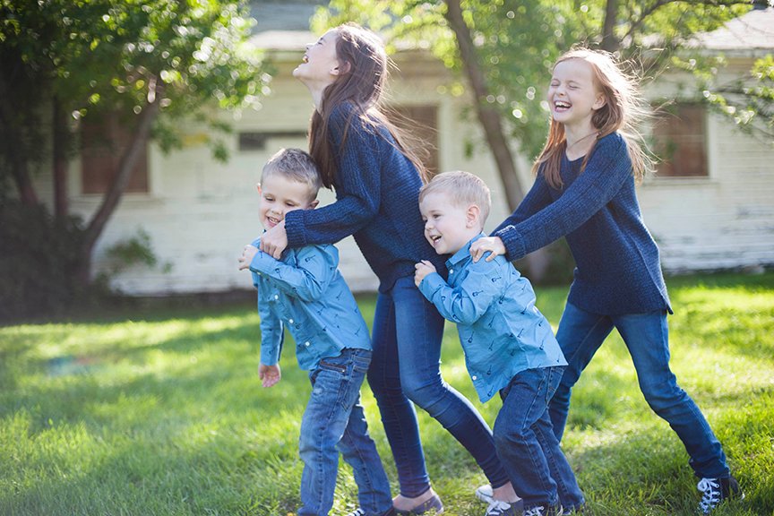 four young kids giggling making a train.jpg