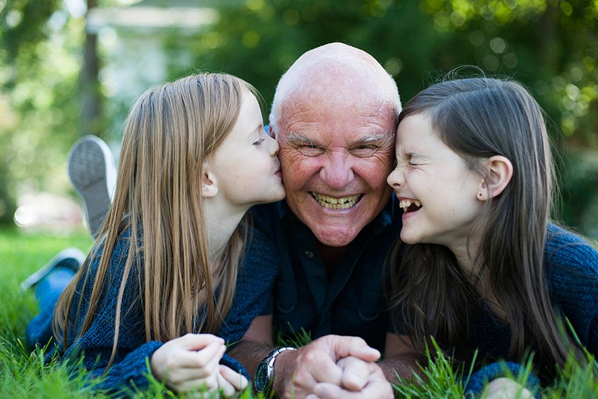 Grandfather laughing and enjoying a sweet moment with his granddaughters.jpg