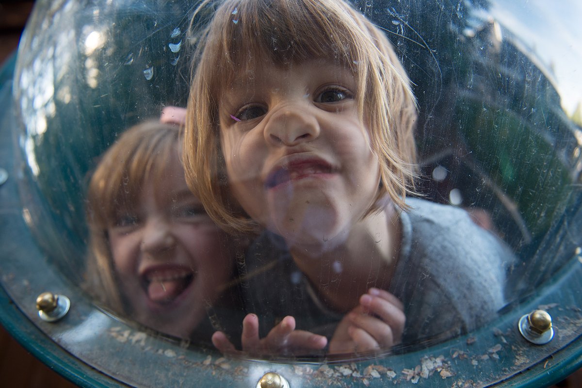 Kids making faces through a window at a playground.jpg