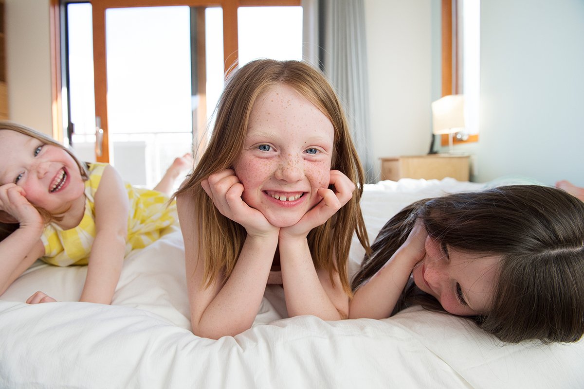 Sisters laughing on a bed.jpg