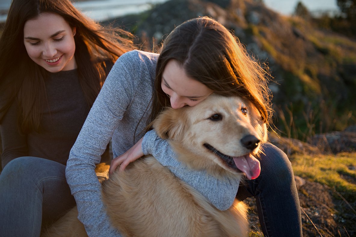 Teeage girls sharing a moment with their golden retriever.JPG