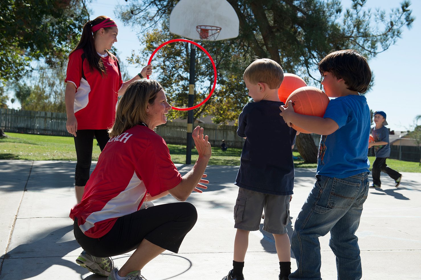 Sportball coach showing kids how to shoot a basketball.jpg