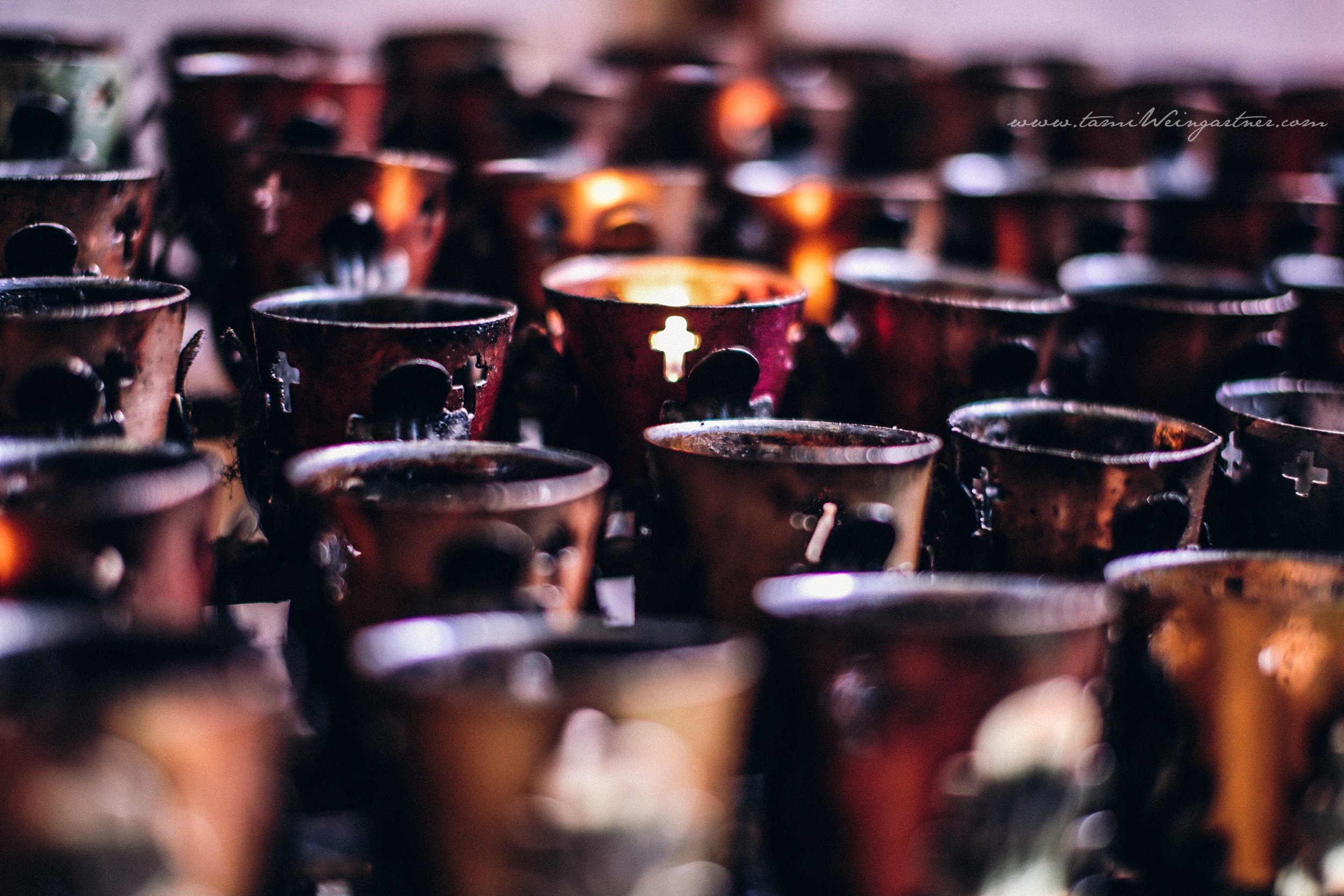 Beautiful glowing votive intention candles in a catholic church the day of a wedding.