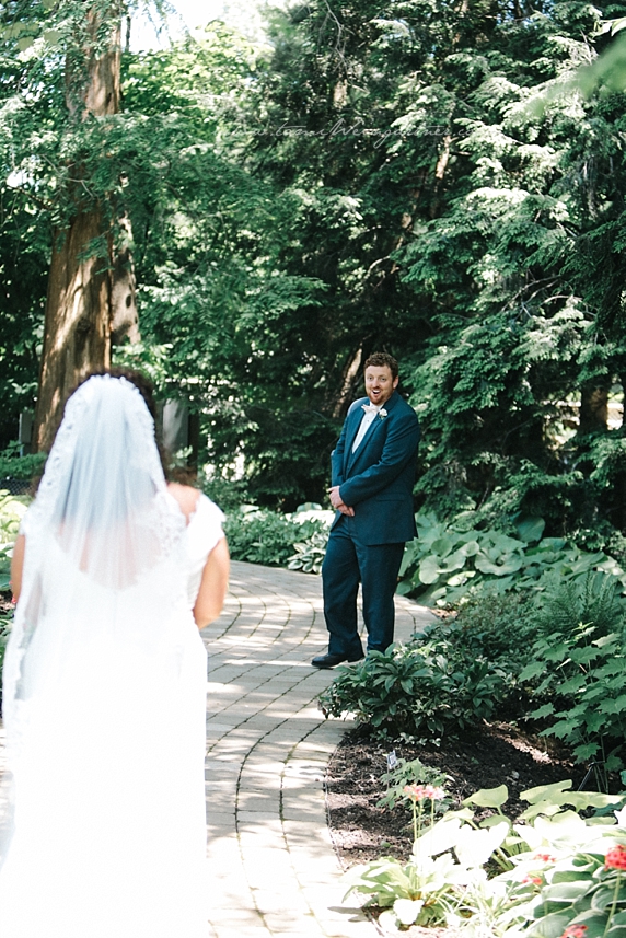 Groom getting first look at bride in sunken japanese garden in Fellows Riverside Garden in Youngstown OH