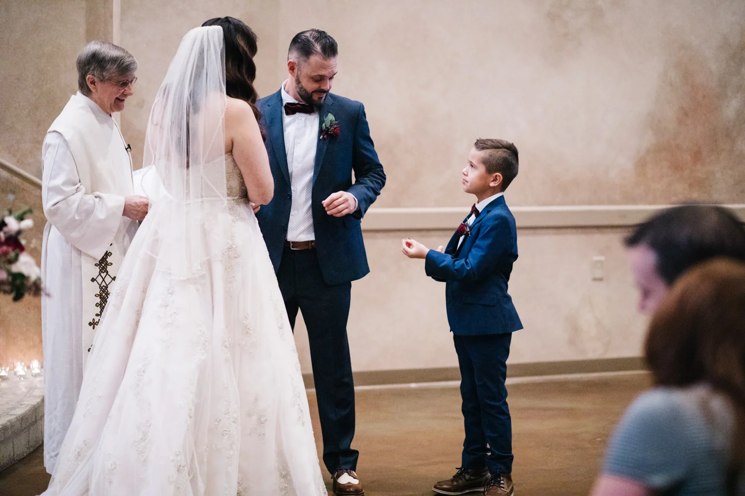 Brides son and best man handing the rings for the exchange to the groom