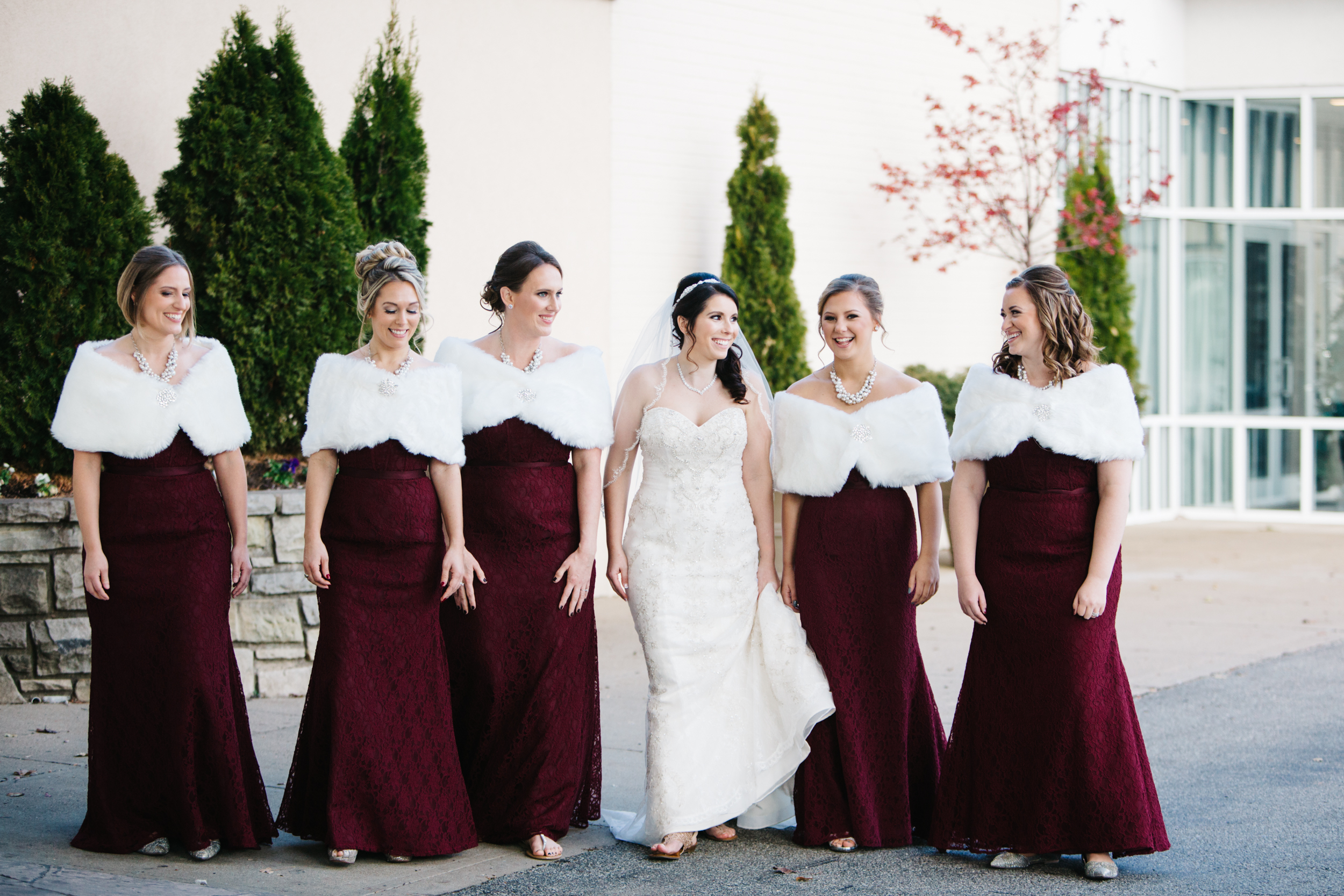 December wedding palette. Textured burgundy bridesmaid dresses with fur caplet.