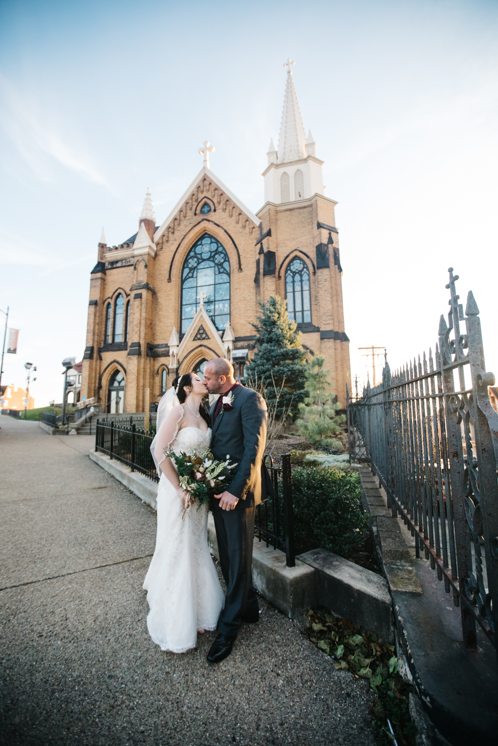 Wedding couple kissing in front of St. Mary of The Mount in Pittsburgh PA