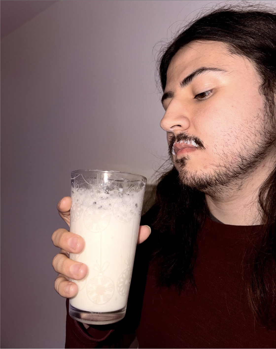 Andrew Fikter holding a glass of milk with a 'milkstache' 