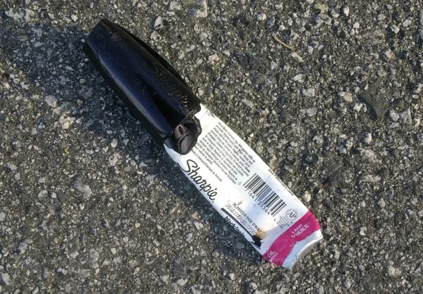 black plastic Sharpie pen cap laying in the street