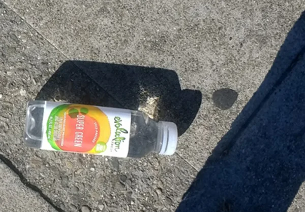 Super green bottle laying on the street.