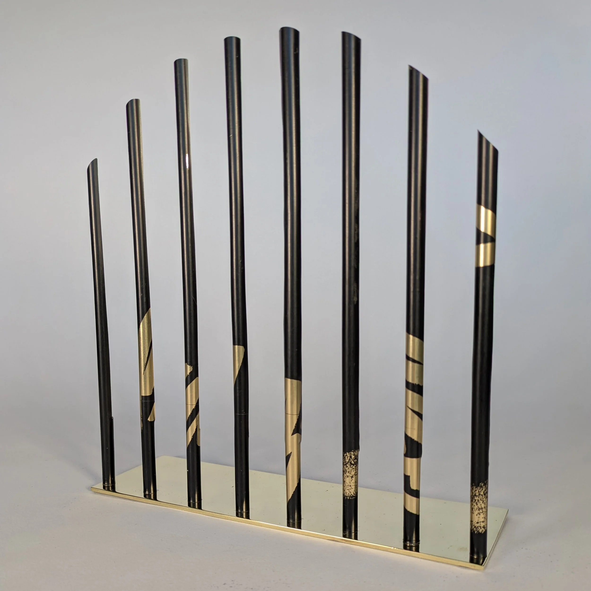Display stand for the Gold Card Visa bracelet. This is the side with the black bars to resemble prison bars, and the border wall between  the United State and Mexico