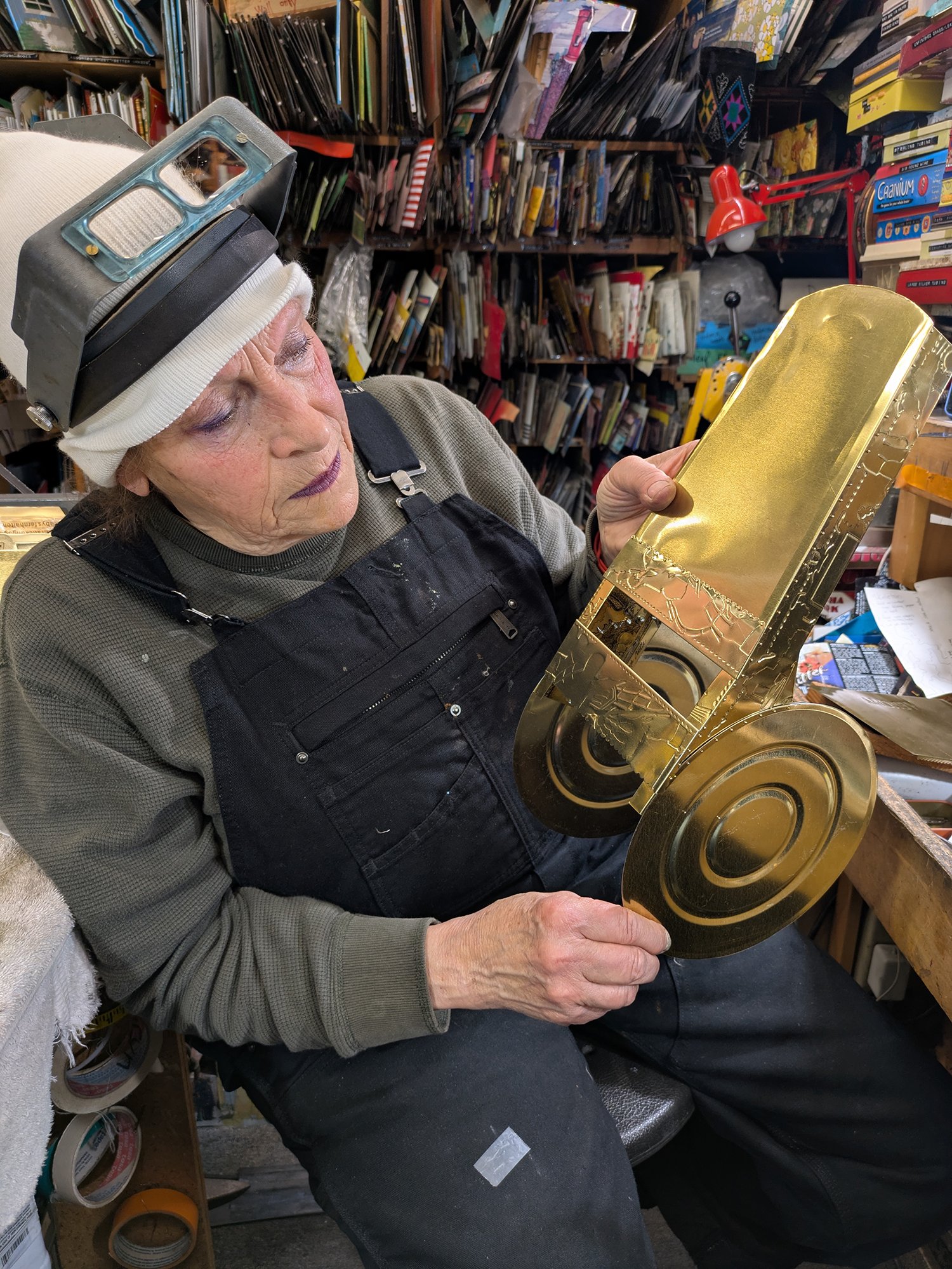 Harriete Estel Berman working on the Gold Gilt Collection “We Need a Bigger Whistle”  work in progress from metallic gold tin cans.’