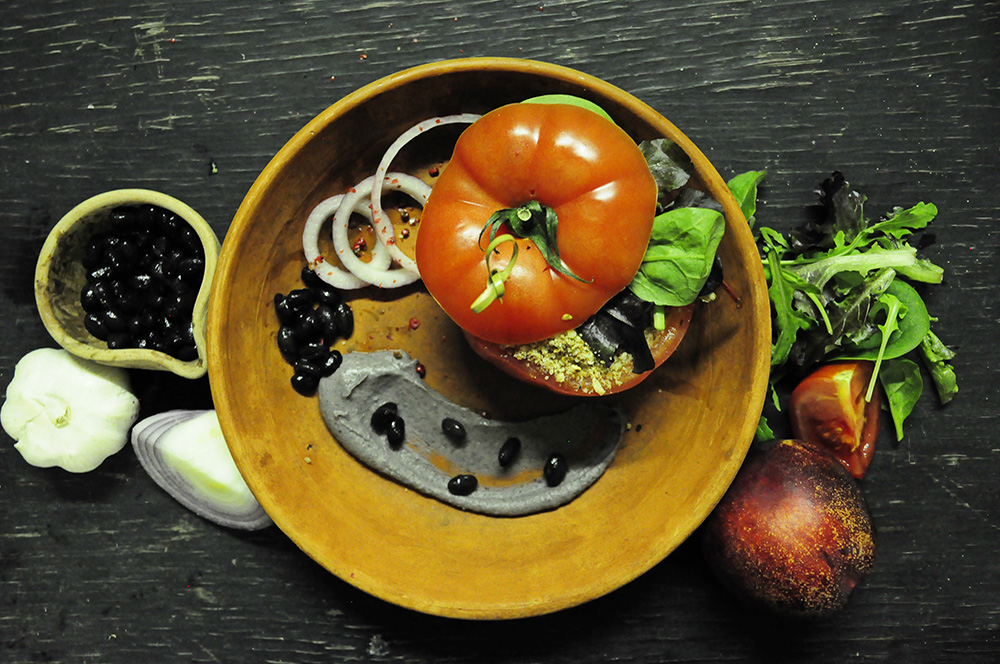 Vegan Main Course Beef Tomato stuffed with raw Ratatouille & Hickory, Tahini and Lime smoked Black Bean Hummus served with Almond Porcini Crumble