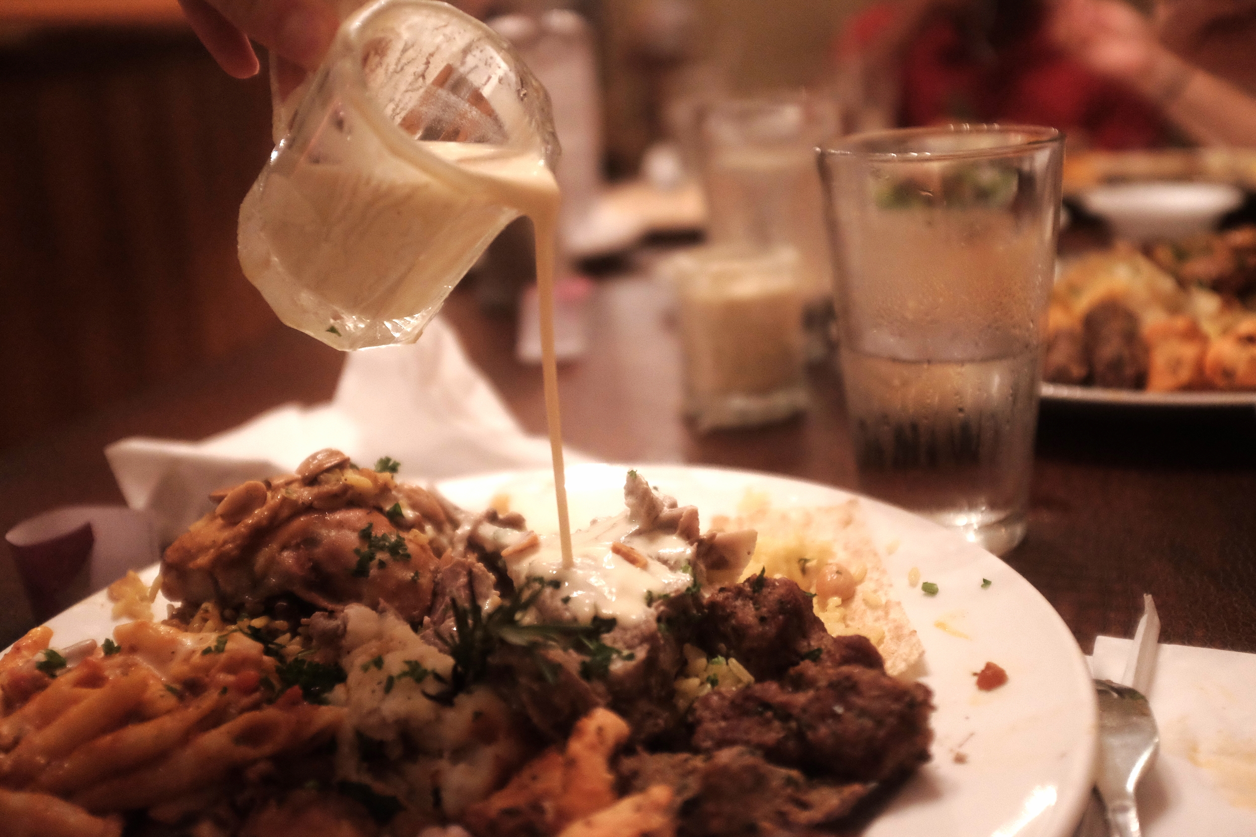 The yogurt goes poured over the lamb and rice. Taste before you pour. If you like sharp cheeses you will find it delightful. 