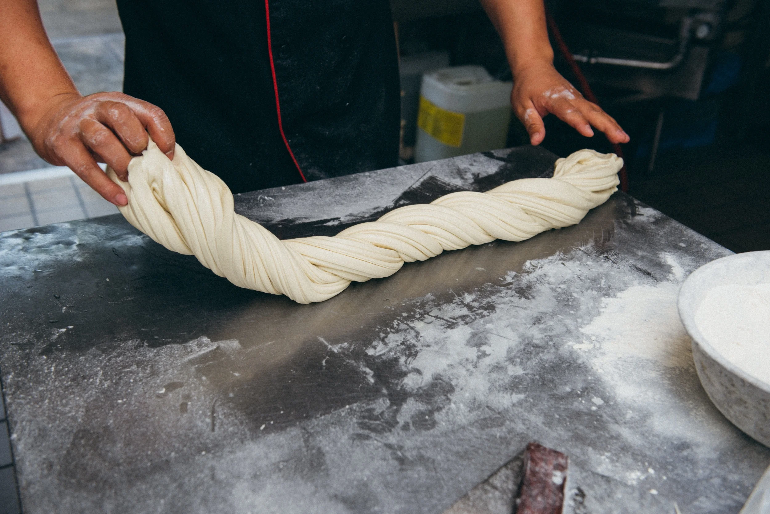 6. Then the noodles are twisted again, slammed against the table, and stretched and folded again.