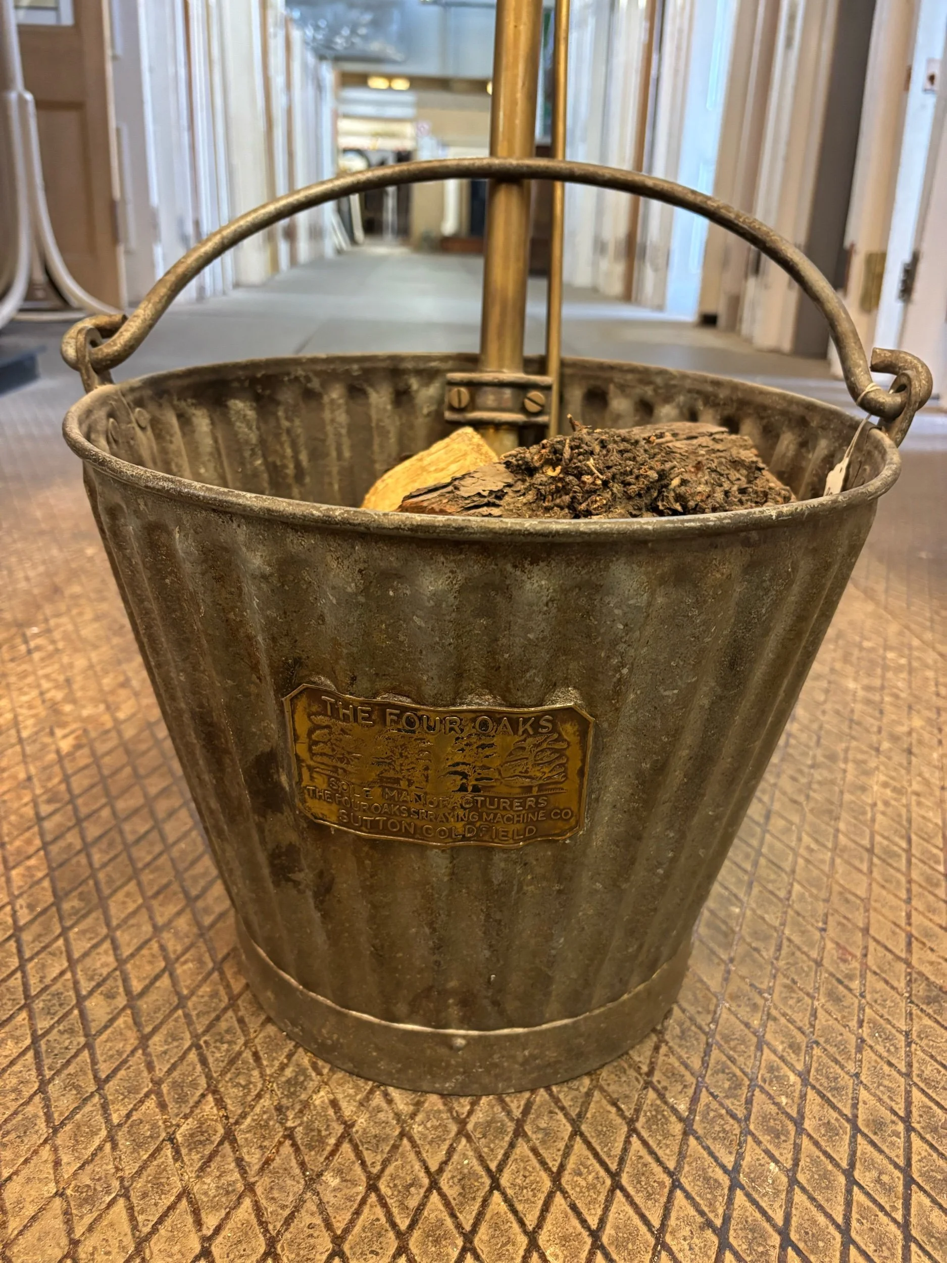 antique stirrup pump fire extinguisher with galvanised bucket, brass pump, and maker's plaque by Four oaks.