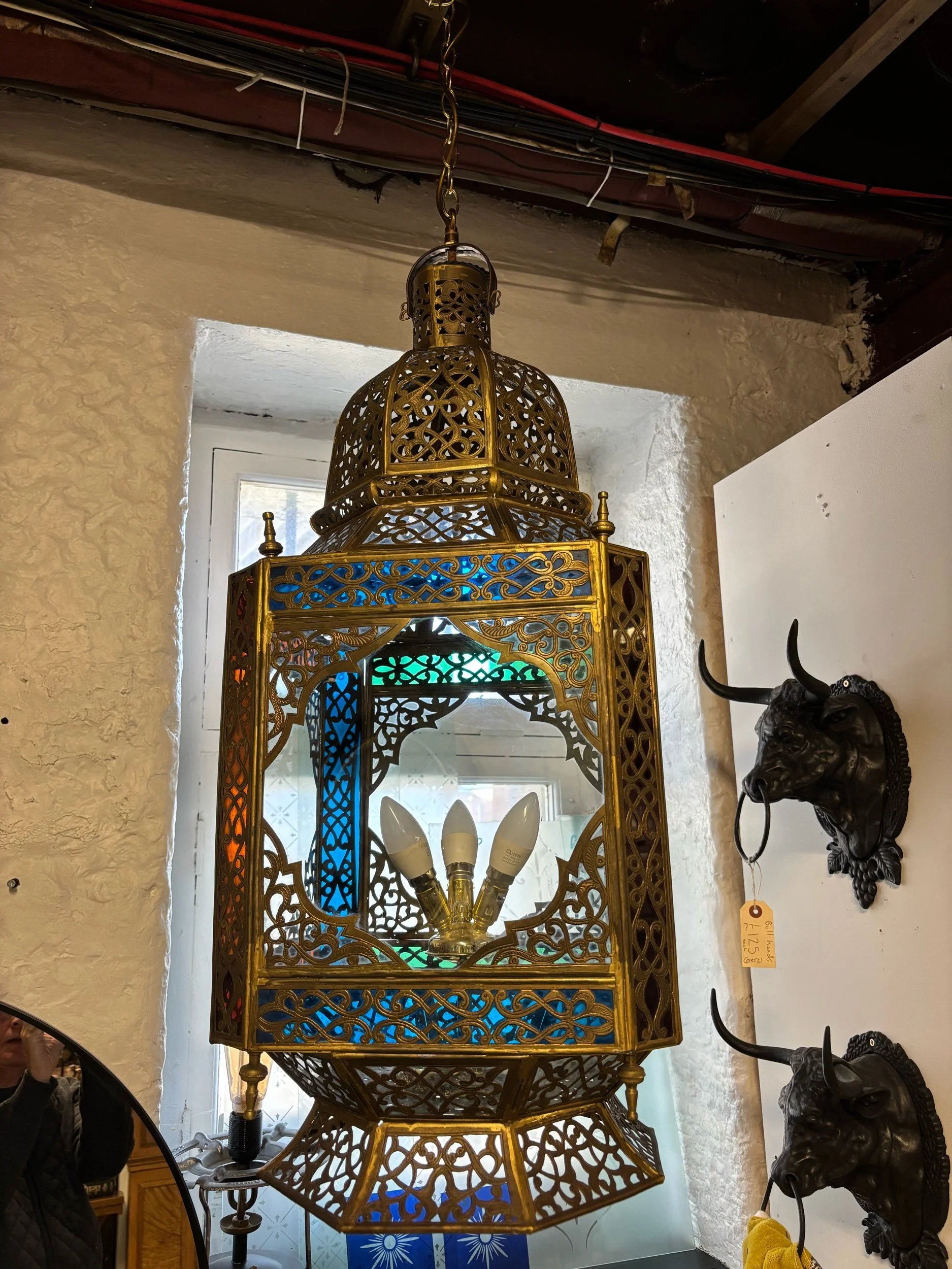 large Moroccan brass lantern light with pierced design and coloured glass panels.
