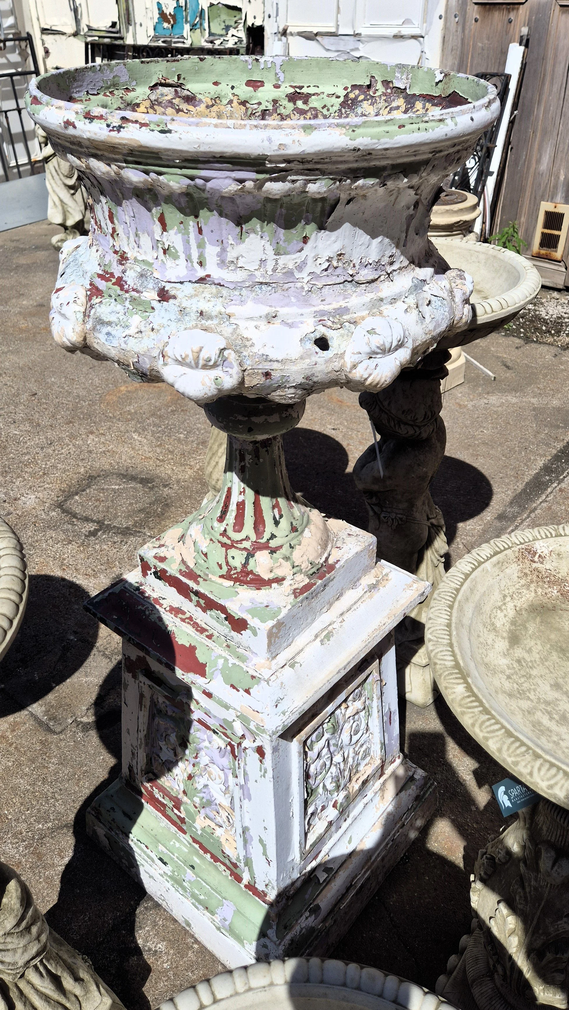 The antique urn features classical moulded decoration with bold gadrooning and scrolled details