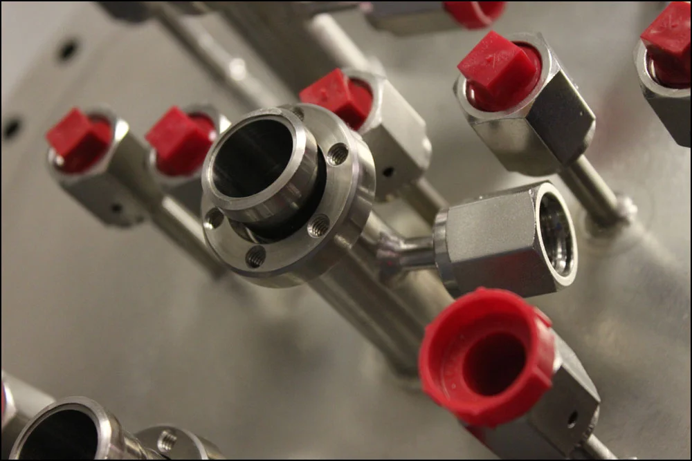 A custom vacuum chamber lid with coolant ports.